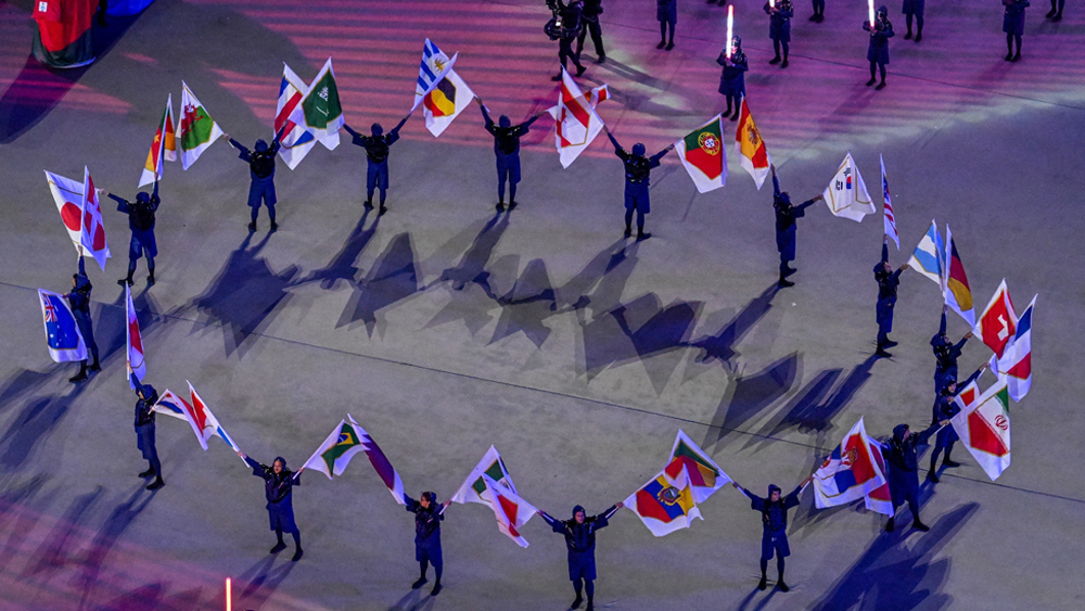 Các nghệ sĩ trình diễn quốc kỳ của 32 đội tuyển tham gia tranh tài tại World Cup 2022 trong lễ khai mạc. Ảnh: AFP/TTXVN.