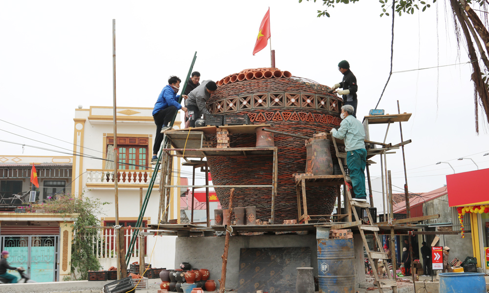 Những nghệ nhân, người thợ đang khẩn trương thi công chiếc chum gốm - biểu tượng của làng- bằng hàng nghìn mảnh gốm, lọ hoa nhỏ.