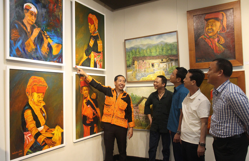 Họa sĩ Hướng Tâm Đường giới thiệu tác phẩm của mình tại triển lãm.