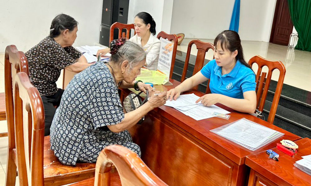 Cán bộ BHXH tỉnh chi trả lương hưu và trợ cấp BHXH cho các đối tượng trên địa bàn phường Dĩnh Kế (TP Bắc Giang).