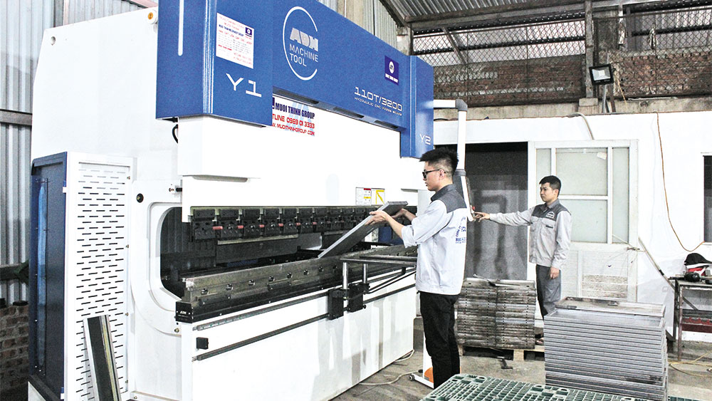 Công nhân Công ty cổ phần Xây lắp điện Hợp Thành làm việc tại khu vực máy gấp mép tôn.