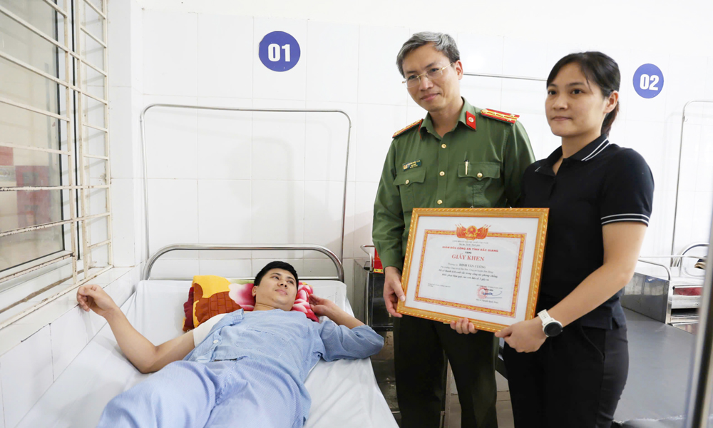 Đại tá Nguyễn Quốc Toản trao tặng Giấy khen ghi nhận những thành tích xuất sắc trong phòng, chống lụt bão của Thượng úy Đinh Văn Cường.