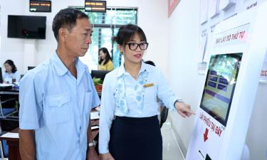 Cán bộ Trung tâm Phục vụ hành chính công xã Tân Chi hướng dẫn người dân lựa chọn, đăng ký lĩnh vực nộp hồ sơ.