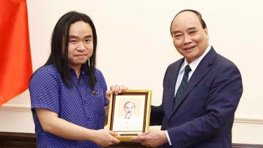 Chủ tịch nước Nguyễn Xuân Phúc tặng ảnh Chủ tịch Hồ Chí Minh cho dịch giả trẻ Nguyễn Bình.
