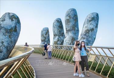Du khách tham quan chụp ảnh tại cầu Vàng khu du lịch Sun World Ba Na Hills. Ảnh: TTXVN phát