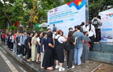 Dòng người xếp hàng dài trên vỉa hè trước trụ sở Báo Nhân Dân, háo hức chờ đợi để vào tham quan triển lãm và nhận ấn phẩm đặc biệt.