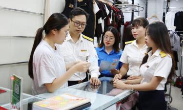 Cán bộ Thuế tỉnh và Thuế cơ sở 1 tuyên truyền về chính sách thuế cho hộ kinh doanh tại phường Bắc Giang. Ảnh tư liệu.