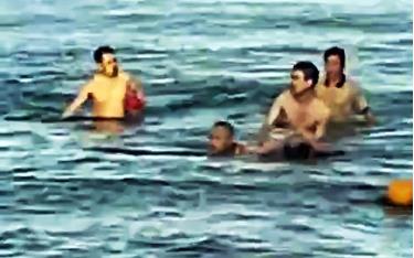 Hình ảnh Trung tá Quân nhân chuyên nghiệp Bùi Văn Nhiên cùng người dân cứu cháu bé bị đuối nước. (ẢNH: QĐND)