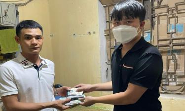 Anh Tạ Văn Minh (bên phải) trả lại tài sản cho người dân. Ảnh: Quỳnh Dương.