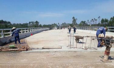 Nhà thầu tập trung nhân lực vệ sinh mặt cầu để chuẩn bị thảm nhựa.