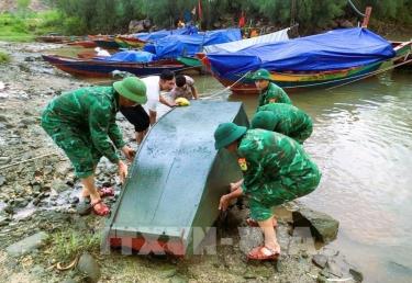 Cán bộ, chiến sĩ Đồn Biên phòng cửa khẩu cảng Cửa Lò - Bến Thuỷ (Bộ đội Biên phòng tỉnh Nghệ An) tăng cường lực lượng xuống địa bàn phối hợp với chính quyền địa phương, các lực lượng hỗ trợ ngư dân đưa thuyền cá lên bờ tránh trú bão. Ảnh: TTXVN phát
